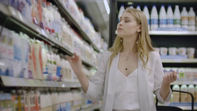 女人在杂货店挑选和购买新鲜的有机乳制品。视频素材