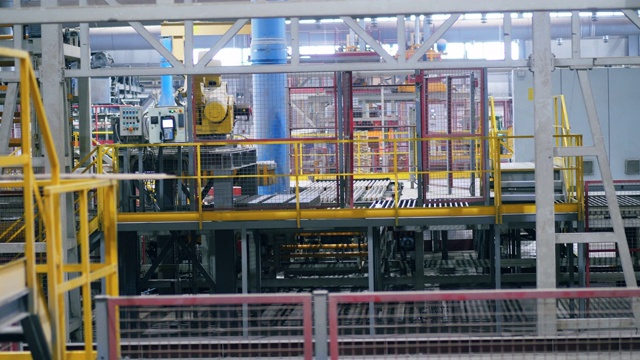 黄色的机器在工厂里搬砖。视频素材