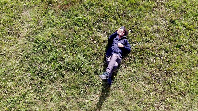 男子躺在草地上，在空中自拍视频下载