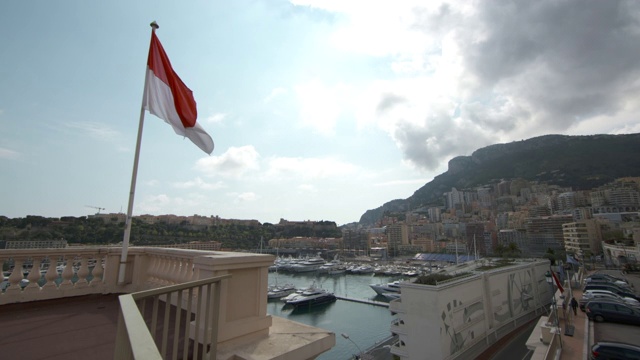 广角摩纳哥港与摩纳哥国旗在前景飞行视频下载