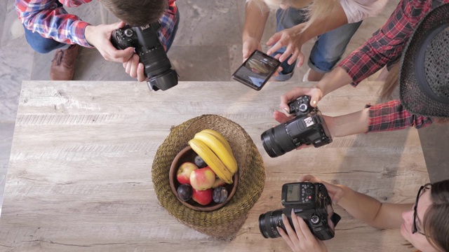 摄像师用数码相机和手机拍下木桌上篮子里的水果，特写视频下载