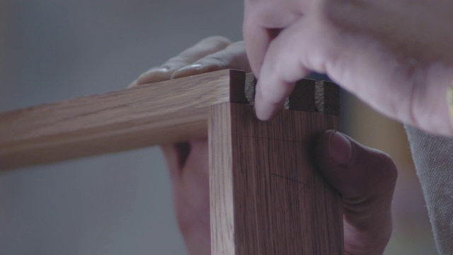 一个木匠的手标记与木工刀在一个木制部分使用燕尾技术的特写。4 k。4 k的视频。缓慢的运动。24帧/秒视频素材