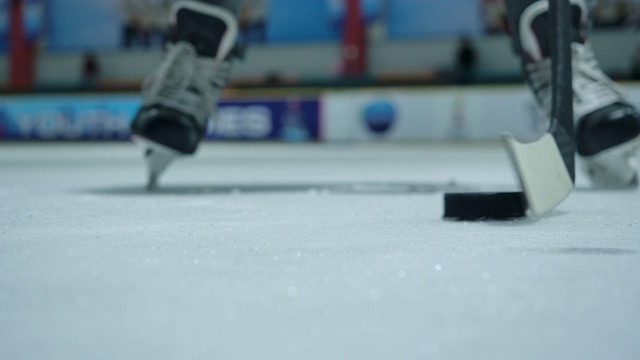 4K慢动作近距离冰球运动员正在练习使用曲棍球棒运球。冰上曲棍球溜冰场视频下载