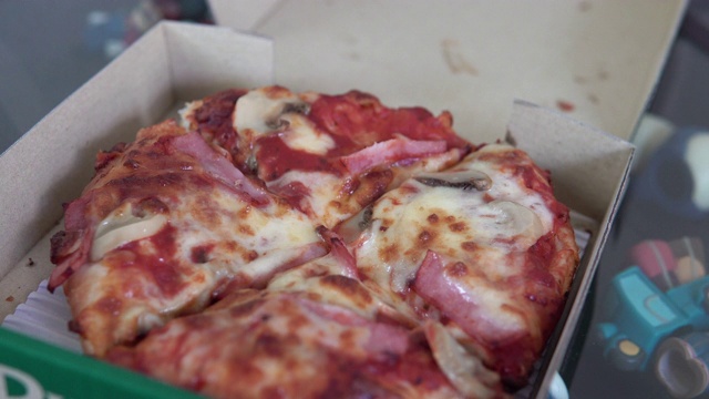 从盒子里拿起一块披萨。视频素材