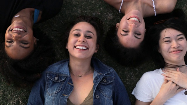 四个女性朋友躺在草地上视频素材