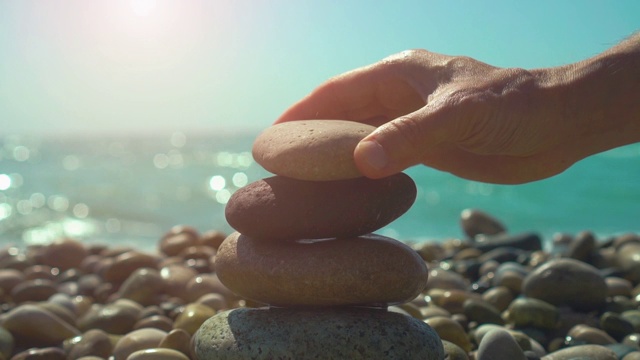 手筑石金字塔在卵石滩上，有稳定、禅意、和谐、平衡的概念视频素材