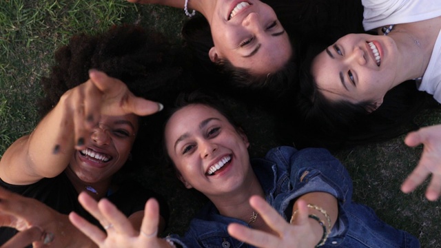 四个女性朋友躺在草地上视频素材
