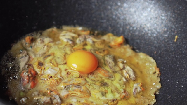 用蛋糊煎贻贝制成的。亚洲食品。泰国菜。加入鸡蛋。缓慢的运动。视频素材