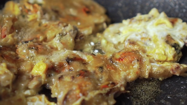 用蛋糊煎贻贝制成的。亚洲食品。泰国菜。翻转许多碎片。慢动作视频素材