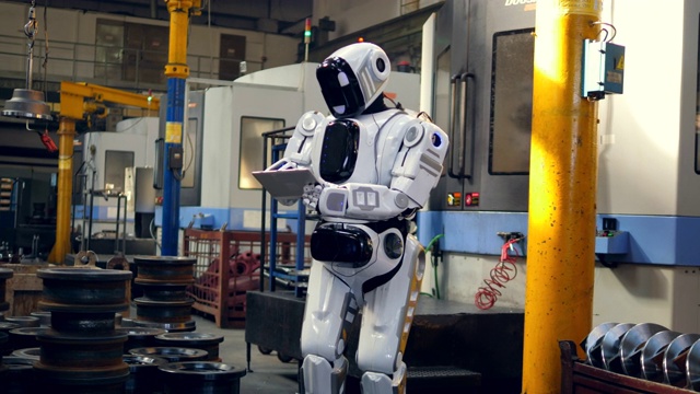仿人机器人正在工厂里用平板电脑工作视频素材