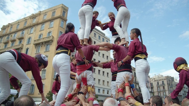 来自加泰罗尼亚的Castellers人类金字塔团队。背景上是一面巨大的加泰罗尼亚旗帜视频下载