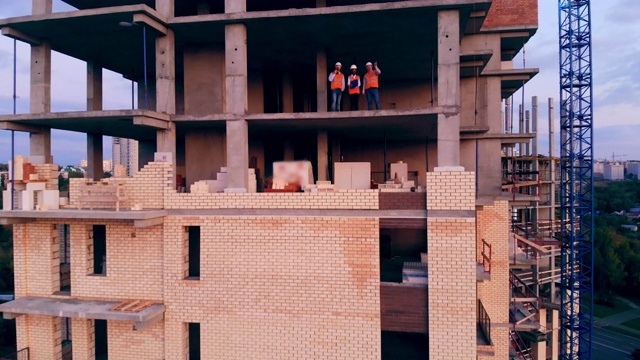 建筑师们正站在一座正在建造中的多层房子里视频素材