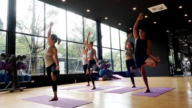 亚洲运动女性和白种白人训练瑜伽在瑜伽工作室教练，开放的光来自自然。健康、城市生活方式理念。慢动作镜头。视频素材