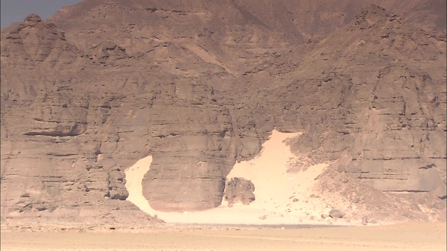 在Gilf Kebir，沙子与巨大的岩壁相遇。视频下载