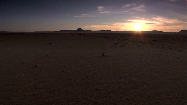 在撒哈拉沙漠的一个贫瘠地区，太阳从地平线上升起。视频下载