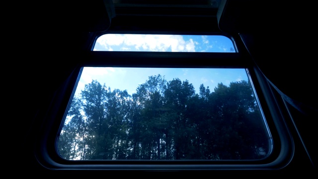火车窗外的森林，关上了。铁路上行驶的火车靠近森林。视频素材