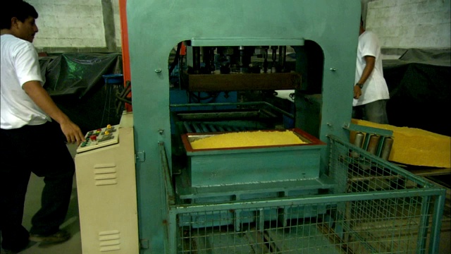 橡胶厂的工人把一块块的橡胶放进模子里。视频素材