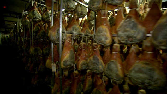 猪肉加工厂的货架上排着熏火腿。视频下载