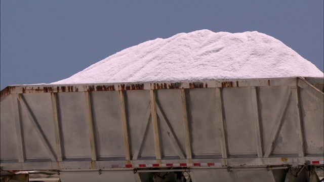 一辆卡车把成堆的盐运走。视频素材