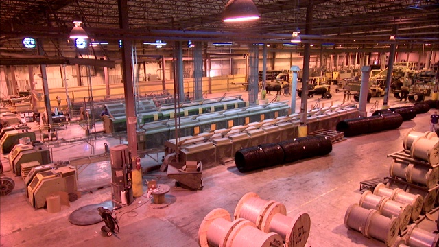 工业工人和重型机械在工厂里移动。视频下载
