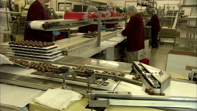 在七叶树糖果工厂，工人们整理和包装巧克力。视频下载