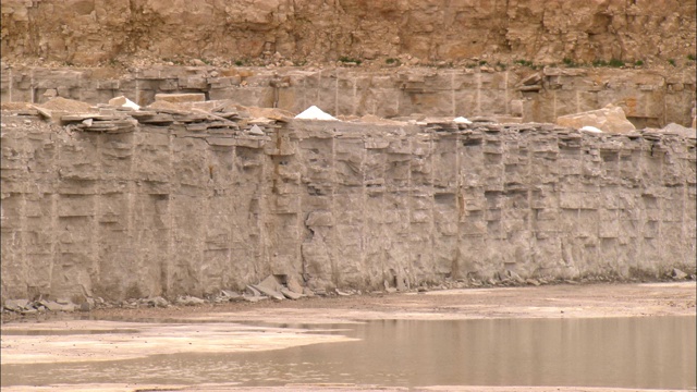 一条浑浊的河流流过一个石灰石采石场。视频素材