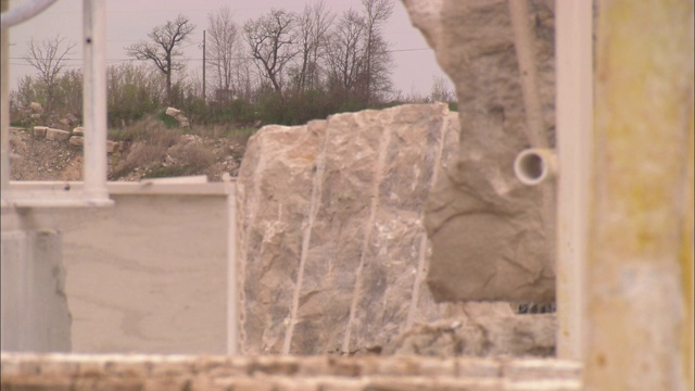一件重型设备在采石场卸下一块石灰石。视频下载