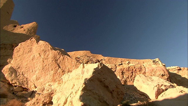 Gilf Kebir的沙漠岩石住宅与蓝天形成了鲜明的对比。视频下载