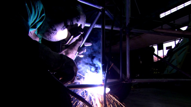 焊工在金属框架上工作。视频下载