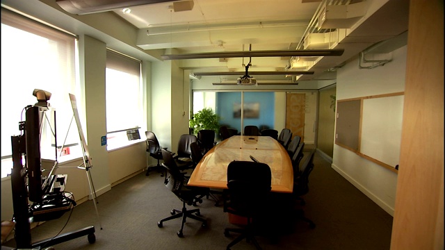在一间空会议室里，黑色的椅子围绕着一张会议桌。视频下载