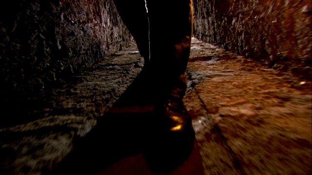 一名游客穿过巴黎地下的地下墓穴。视频下载