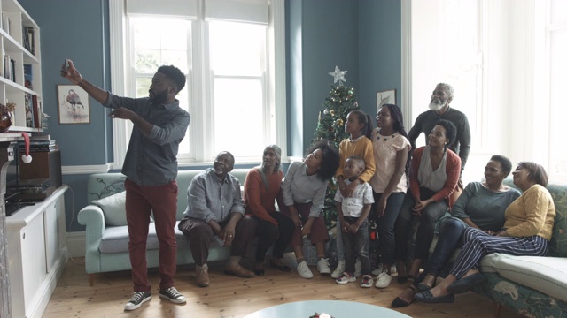 一名非裔美国男子在圣诞节与家人自拍，中景视频下载
