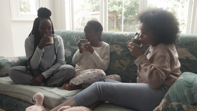 近距离观看，非裔美国青少年坐在沙发上喝热巧克力视频下载
