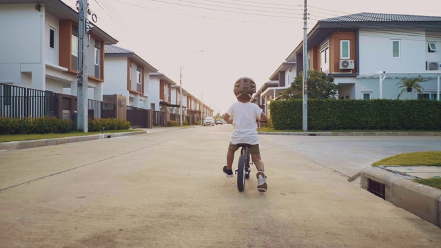 蹒跚学步的孩子骑着平衡自行车。视频下载