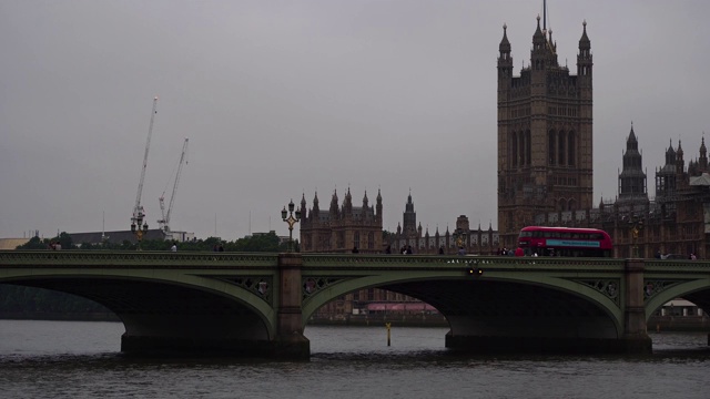 红色双层巴士驶过英国伦敦标志性大桥。视频素材