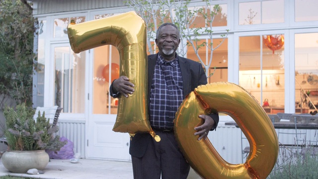 中景，年长的非裔美国人拿着生日气球视频下载