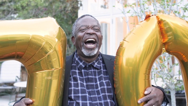 快乐的非裔美国人拿着生日气球，特写视频下载