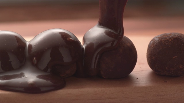 巧克力倒在松露上的慢动作。视频素材