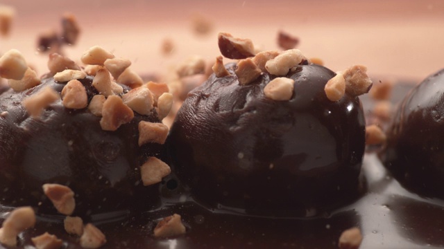 用超级慢动作将坚果倒在巧克力松露上。视频素材