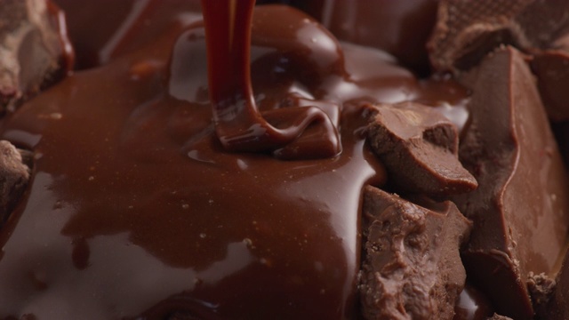 融化的巧克力倾泻在巧克力块上视频下载