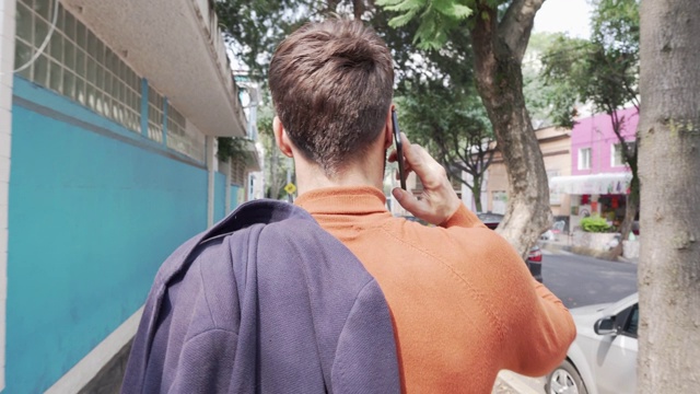 英俊的男人在街上用手机。视频下载