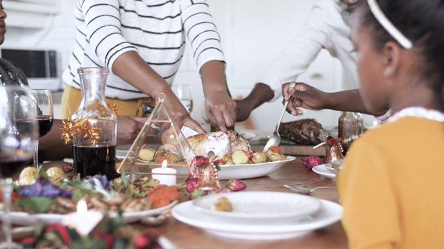 非裔美国家庭在圣诞节切鸡肉，特写视频素材