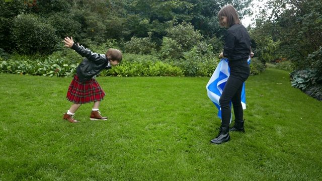 苏格兰的兄弟姐妹在玩苏格兰国旗。视频下载