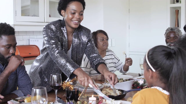 一位非裔美国妇女正在供应圣诞晚餐，中杯烈酒视频素材