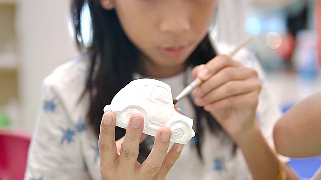 亚洲女孩在艺术家工作室画石膏娃娃，生活方式概念。视频下载
