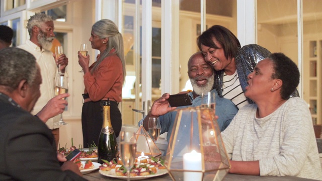 非裔美国人家庭在户外的桌子上大笑，中镜头视频素材