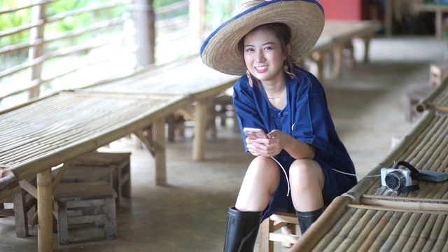 年轻的亚洲女性穿着泰国北部的毛洪传统衬衫，微笑着看着镜头。视频下载