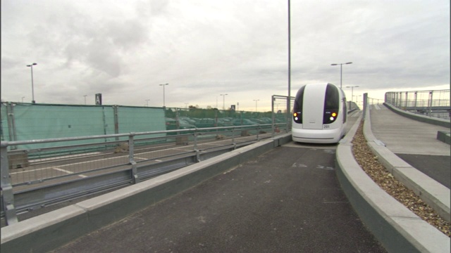 一个吊舱在英国伦敦希思罗机场附近一条狭窄的轨道上行驶。视频下载
