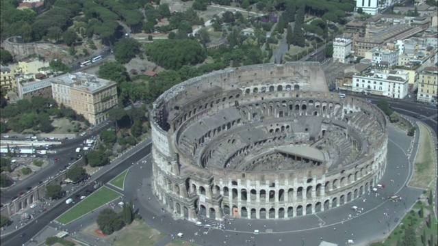 车辆川流不息地经过罗马圆形大剧场。视频下载