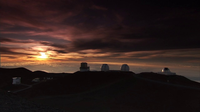 在夏威夷莫纳克亚的W. M.凯克天文台的望远镜附近，阳光穿过云层。视频下载